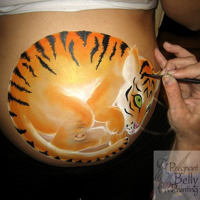 Painting a tiger on a pregnant belly